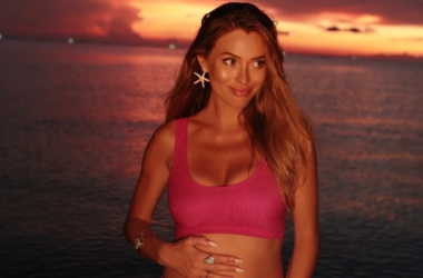 Marcelina Zawadzka pozuje na plaży, obejmując ciążowy brzuch